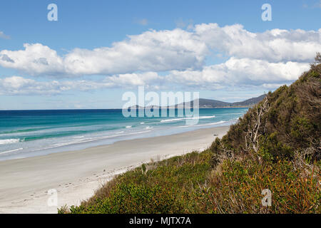 Bellissima spiaggia di sabbia bianca sulla costa est della Tasmania lungo il Tasman highway. Aqua blu del mare e del cielo. Foto Stock