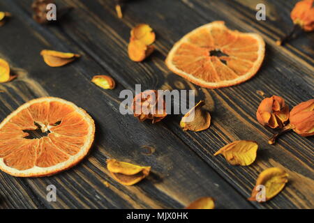 Fette di arancia e ibisco Petali su sfondo di legno. Foto Stock