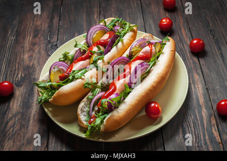 Hot Dog. Grigliata di hot dog con ketchup su un tavolo di legno. Sandwich Foto Stock