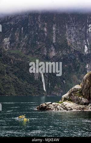 MILFORD SOUND, Nuova Zelanda - 14 novembre 2017: Kayakers godere il paesaggio e le cascate di Milford Sound, uno della Nuova Zelanda turistiche più famose Foto Stock