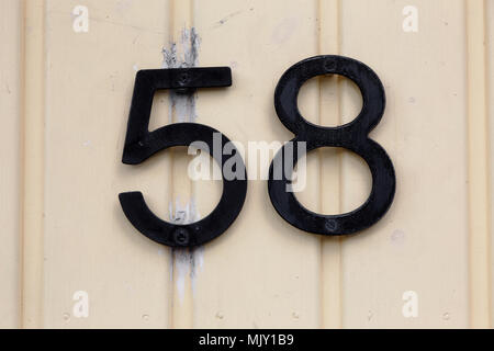 Numero cinquanta otto su giallo parete in legno. Foto Stock