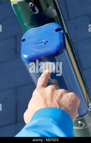 Un dito indice, premere il pulsante a un semaforo controllato del segnale di attraversamento pedonale per ottenere un passaggio sicuro attraverso la strada. Foto Stock