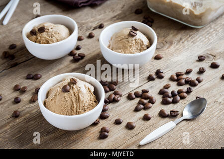 Gelato al caffè su sfondo di legno. In casa Caffè gelato Gelato con i chicchi di caffè - estate sano vegan dessert. Foto Stock