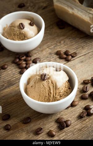 Gelato al caffè su sfondo di legno. In casa Caffè gelato Gelato con i chicchi di caffè - estate sano vegan dessert. Foto Stock