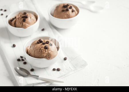 Gelato al cioccolato su sfondo di legno. In casa vegan cheto gelato al cioccolato con scaglie di cioccolato - sano dessert estivo. Foto Stock