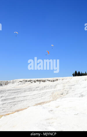 Pamukkale: parapendio volare sopra i depositi di calcio da sorgenti termali naturali. Foto Stock