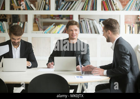 Tre colleghi maschi brainstorming e discutere le idee Foto Stock