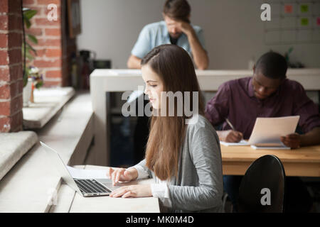 Studentessa studiando per gli esami utilizzando laptop Foto Stock