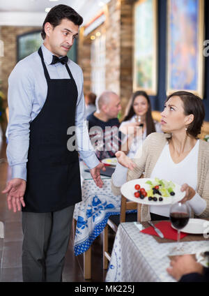 Adulto Giovane esprimere insoddisfazione con il cameriere circa il cibo Foto Stock