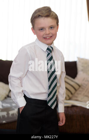 Ragazzo giovane vestito in uniforme nuova e pronta per la scuola Foto Stock