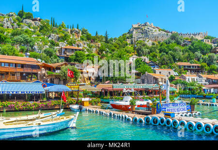 KALEKOY, Turchia - 5 Maggio 2017: Il villaggio di montagna è famosa località turistica nella baia di Kekova con conserva di Lycian tombe e castello bizantino tra lus Foto Stock