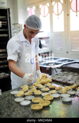 Un panettiere che prepara i tortini di crema portoghese (pasteis de nata) nella cucina della Confeitaria Colombo, Rio de Janeiro, Brasile Foto Stock
