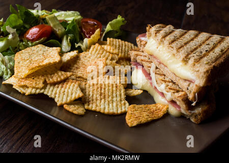 Bagno turco toast o Tost / triangolo Club Sandwich con formaggio fuso, prosciutto e servito con patatine e insalata. Fast Food. Foto Stock