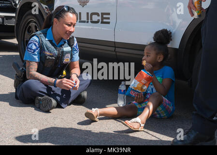 MINNEAPOLIS - 6 Maggio 2018: un bambino non identificato attende con agenti di polizia che tentano di individuare il suo custode dopo Minneapolis' può annuale parata del giorno. Organizzato da nel cuore della bestia burattino e teatro di maschera, la sfilata, cerimonia e festival è nella sua quarantaquattresima anno. Credito: Nicholas Neufeld/Alamy Live News Foto Stock