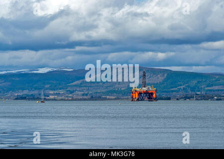 CROMARTY FIRTH Scozia smantellata una piattaforma petrolifera in riparazione giacente fuori coperta di neve colline e Invergordon Foto Stock