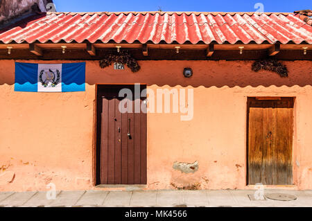 Antigua Guatemala - Ottobre 5, 2014: Vecchia casa dipinta adornata con bandiera Guatemalteca in città coloniale & UNESCO World Heritage Site di Antigua. Foto Stock