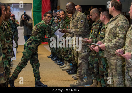 Un afghano Forze Speciali soldato riceve il suo certificato di laurea dal comando Sgt. Il Mag. David Clark, nato sostegno deciso arruolati Senior leader, durante una cerimonia di laurea a Camp Juilen, nov. 8, 2017. Le forze speciali forniscono speciali ricognizione e di azione diretta funzionalità per l'Esercito nazionale afgano il Comando Operazioni Speciali. (U.S. Air Force foto di Senior Airman Sean Carnes) Foto Stock