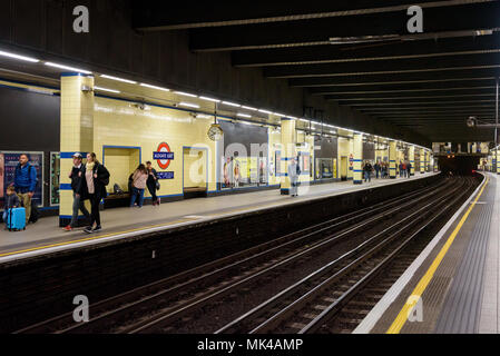 London, Regno Unito - Appril 28, 2018: persone in attesa sulla piattaforma a Aldgate East Stazione della metropolitana Foto Stock