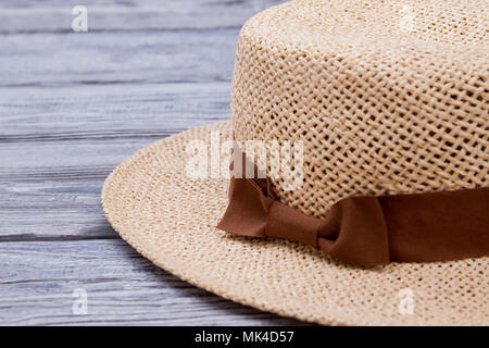 Cappello di paglia sul tavolo di legno, extreme close up. Scrivania in legno sfondo di superficie. Foto Stock