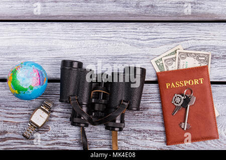 Concetto di viaggio wanderlust elementi, laici piana. Cose di viaggio disposizione sulla scrivania in legno superficie. Foto Stock