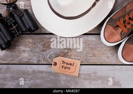 Consigli di viaggio flat laici. Traveler vestiti e binocolo sulla scrivania in legno superficie. Foto Stock