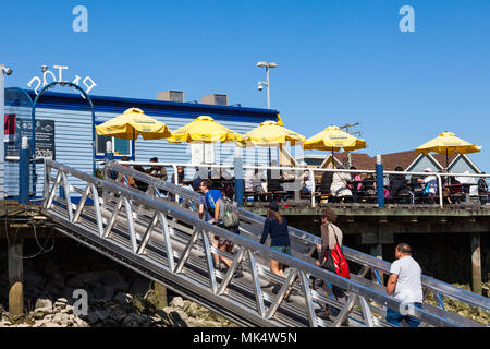 La gente camminare fino ad una passerella da un pesce flottante e di uscita del chip nel porto di Steveston, British Columbia Foto Stock