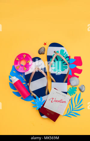 La vacanza estiva laici piatta con spiaggia accessori, flip-flop, protezione solare, passaporto, conchiglie, foglie tropicali su sfondo giallo. Travel Essentials dal di sopra con copia spazio. Moderna tavolozza colorata. Foto Stock