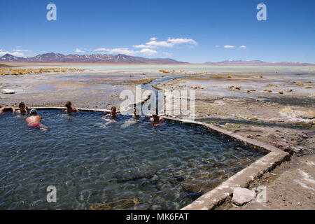 TUPIZA, BOLIVIA - 23 settembre 2011: un gruppo di persone relax nelle terme del Salar de Uyuni mentre godendo la stupefacente scenario desertico Foto Stock