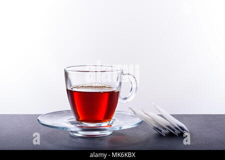 Tazza e piattino con tè su sfondo bianco Foto Stock