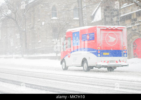 Hamilton, Ontario, Canada - Febbraio 2013: un Canada Post consegna carrello tenta di effettuare consegne durante forti nevicate Foto Stock