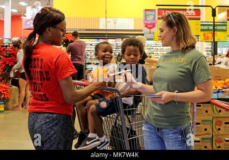 Marsha Byrom (a destra), moglie del Col. Jonathan Byrom, il 77th comandante del terzo reggimento di cavalleria, mani fuori una donazione di alimentare la scheda di richiesta per una shopper durante un cibo locale drive nov. 17, 2017 a Harker Heights, Texas. L'unità alimentare si tiene ogni anno e tutte le donazioni raccolte sono date per il cibo locale le banche che si trovano in tutta la contea. Foto Stock