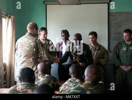 Camerunese Forze Armate Il Mag. Rene Didier Bekada, centro, vice comandante del Cameroon forze armate (scuola di ingegneria, mani fuori bandiera camerunese patch in gesto di amicizia alla cerimonia di laurea di esercizio contatore esplosivi improvvisati Device-Defeat Fase I a Douala Camerun, Novembre 17, 2017. L'esercizio, guidati da U.S. I soldati della 764th Ordnance Company (l'eliminazione degli ordigni esplosivi) fuori di Fort Carson, Colo., insegna potenzialmente salvavita competenze, incluse le modalità per il riconoscimento e lo smaltimento sicuro di IED. La minaccia di IED contatto è rilevante per le truppe camerunesi, WH Foto Stock