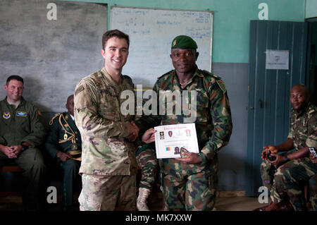 1Lt. Giacobbe Schall, a sinistra un plotone leader per il 764th Ordnance Company (l'eliminazione degli ordigni esplosivi) fuori di Fort Carson, Colo., mani fuori i certificati di laurea al culmine di esercizio contatore esplosivi improvvisati Device-Defeat Fase I a Douala Camerun, Novembre 17, 2017. L'esercizio, guidati da U.S. I soldati della 764th Ordnance Company (l'eliminazione degli ordigni esplosivi) fuori di Fort Carson, Colo., insegna potenzialmente salvavita competenze, incluse le modalità per il riconoscimento e lo smaltimento sicuro di IED. La minaccia di IED contatto è rilevante per le truppe camerunesi, che distribuiscono il lago Ciad Bas Foto Stock