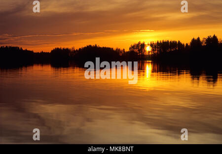 Tramonto con colori intensi sul lago in Finlandia. Foto Stock