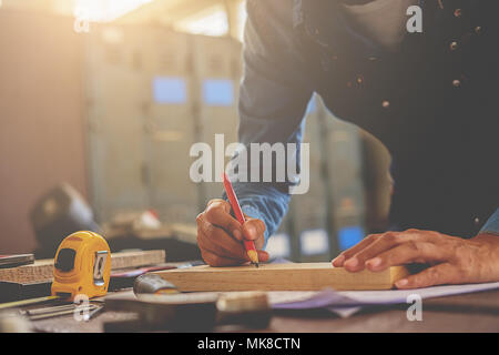 Carpenter lavorando su macchine per la lavorazione del legno in falegnameria shop. donna lavora in un negozio di falegnameria. Foto Stock