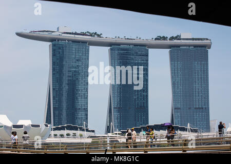 I turisti si trovano sul ponte di fronte al lussuoso hotel di Marina Bay Sands e al Museo delle Scienze dell'Arte nel 2018. Singapore. Foto Stock
