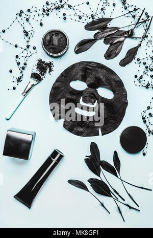 Vari prodotti cosmetici con carbone attivo per la cura della pelle su sfondo chiaro, vista dall'alto, piatto laici. Concetto di bellezza. Il Branding mock up Foto Stock