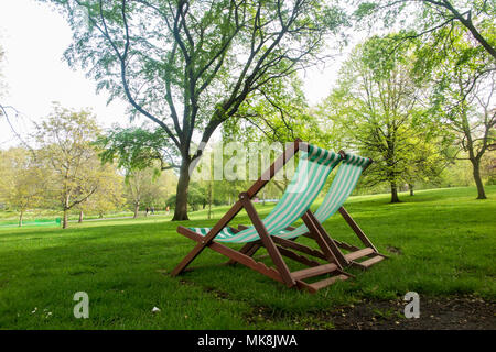 Due sedie a sdraio in St James Park in attesa di utilizzo in un parco deserta Foto Stock