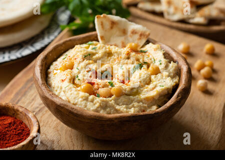 In casa di ceci hummus ciotola con pita chips e paprika. Vista ingrandita, il fuoco selettivo Foto Stock