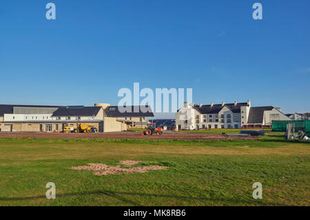 Un trattore e gli appaltatori che lavorano sui preparativi per il prossimo Golf Open Championship tenutosi nel 2018 a Carnoustie, Angus, Scozia. Foto Stock