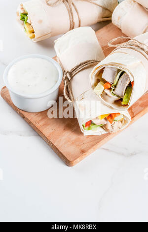 Un sano pranzo snack. Pila di messicano cibo di strada fajita tortilla avvolge con grigliate di buffalo filetto di pollo e verdure fresche, grigio chiaro backgroun Foto Stock