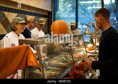 Col. Jennifer breve, 23d Wing Commander, sinistra, serve cibo di Airman 1. Classe Tristan Batten, 23d' ingegnere civile Squadron acqua combustibili e la manutenzione del sistema tecnico, il giorno del Ringraziamento in Georgia Pini Dining Facility, nov. 23, 2017, a Moody Air Force Base, Ga. La Giornata del Ringraziamento pasto è stata un opportunità per aviatori, pensionati, dipendenti e la leadership di gustare un tradizionale pasto del Ringraziamento. (U.S. Air Force foto di Airman 1. Classe Erick Requadt) Foto Stock