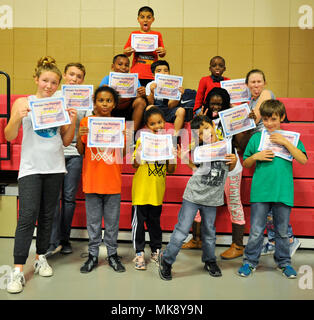 I bambini pongono con Ambra precoce, Centro Giovanile per bambini e giovani Assistente programma, dopo aver ricevuto i premi di partecipazione in Sam è il centro fitness a base comune Charleston - stazione delle armi, S.C., nov. 16, 2017. Le cerchiature per fame è un bi-annuale di servizio alla comunità progetto ospitato da Programmi Giovanili dove conserve alimentari sono donati ai rifugi locale. (Foto di Airman 1. Classe Allison Payne) Foto Stock