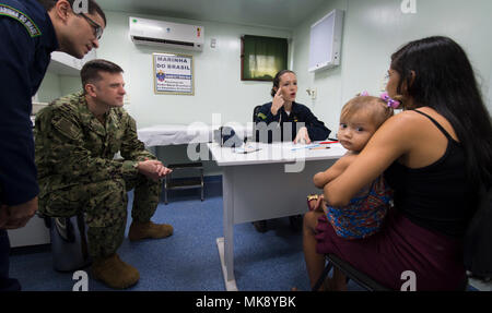 171122-N-QM691-0202 fiume del Amazon, Brasile (nov. 22, 2017) Lt. La Cmdr. Robert P. Lennon, uno specialista in medicina generale (secondo da sinistra), funziona con 1Lt. Priscila Tomy Ribeiro, un brasiliano medical officer (terza da sinistra), per effettuare la diagnosi di una giovane madre a bordo di NAsH Soares de Meirelles vicino a un remoto villaggio lungo il Rio delle Amazzoni in Brasile, 22 novembre. Lennon è un membro di una squadra di cinque Stati Uniti Navy medici che sono impegnati in un mese di missione umanitaria fino il fiume del Amazon. Il team sta lavorando con la Marina brasiliana per offrire assistenza sanitaria di alcuni dei più persone isolate nel mondo. (U.S Foto Stock