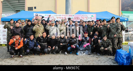 Soldati assegnato al campo 210th brigata di artiglieria, seconda divisione di fanteria/ROK-US Divisione combinata e 125th meccanizzata del battaglione di fanteria, Repubblica di Corea 26 dell esercito meccanizzato di divisione di fanteria prendere una foto di gruppo con persone provenienti da comunità locali organizzazioni durante il 2017 Dongducheon Centro di volontariato Kimchi annuale evento di beneficenza a Dongducheon multi stadio complessa, Dongducheon, Repubblica di Corea, nov. 22, 2017. Alla manifestazione hanno fatto Kimchi e li ha distribuiti ad anziani che erano nel bisogno. (U.S. Esercito Foto di Sgt. Michelle U. Blesam, 210th FA Bde Affari pubblici) Foto Stock