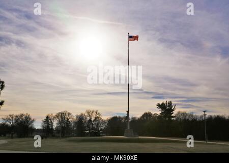 Bandiera degli Stati Uniti d'America è illuminata da un fondale di sole del pomeriggio nov. 27, 2017, mentre si è in volo sul pennone di fronte la sede di guarnigione a Fort McCoy, Wis. il tempo per la fine del mese di novembre è stato unseasonably caldo con temperature intorno ai 50 gradi Fahrenheit. (U.S. Foto dell'esercito da Scott T. Sturkol, Ufficio per gli affari pubblici, Fort McCoy, Wis.) Foto Stock