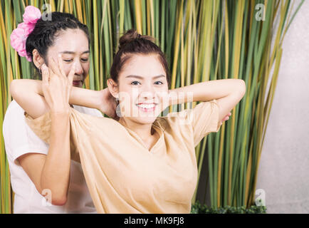 Donna felice è ottenere il massaggio thai stretching posizione Foto Stock