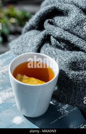 Close up white tazza di tè al limone avvolto in una coperta Foto Stock