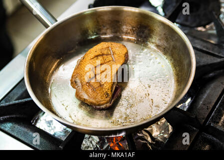 Bistecca di pesce nella padella di ferro vicino Foto Stock