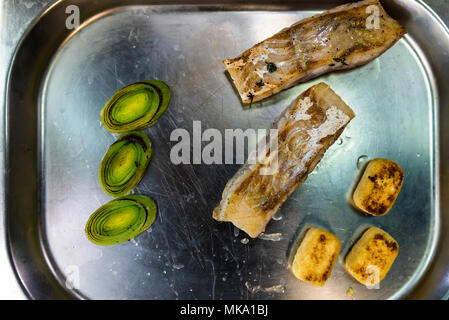 Bistecca di pesce con verdure sul vassoio di metallo Foto Stock